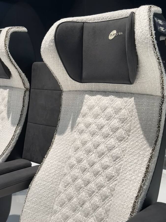 Close-up of quilted bouclé upholstery and headrest on a Clerprem seat